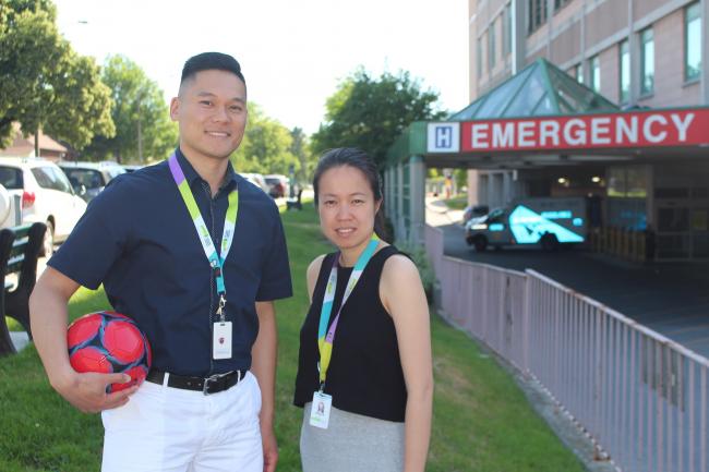Andrew Liu, Clinical Manager, Pharmacy and Grace Ho, Pharmacist pictured with a soccer ball outside the Michael Garron Hospital Emergency Department