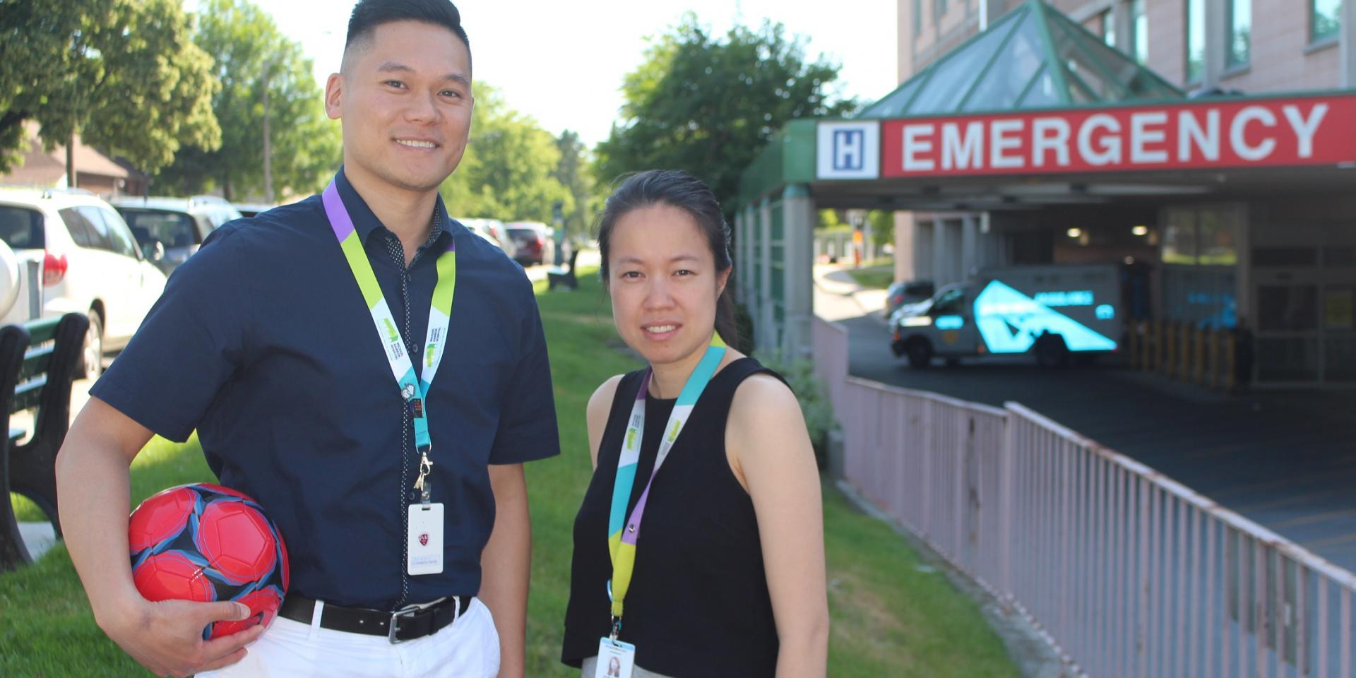 Andrew Liu, Clinical Manager, Pharmacy and Grace Ho, Pharmacist pictured with a soccer ball outside the Michael Garron Hospital Emergency Department