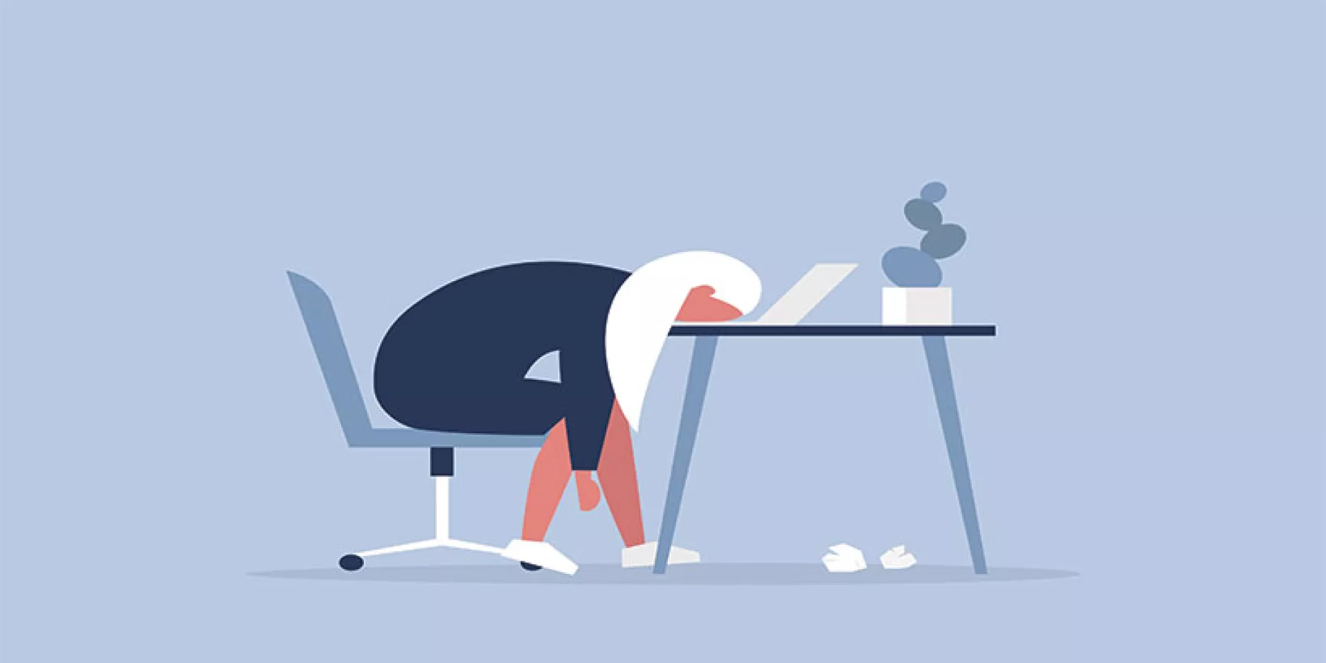 person sitting at desk with head slumped down