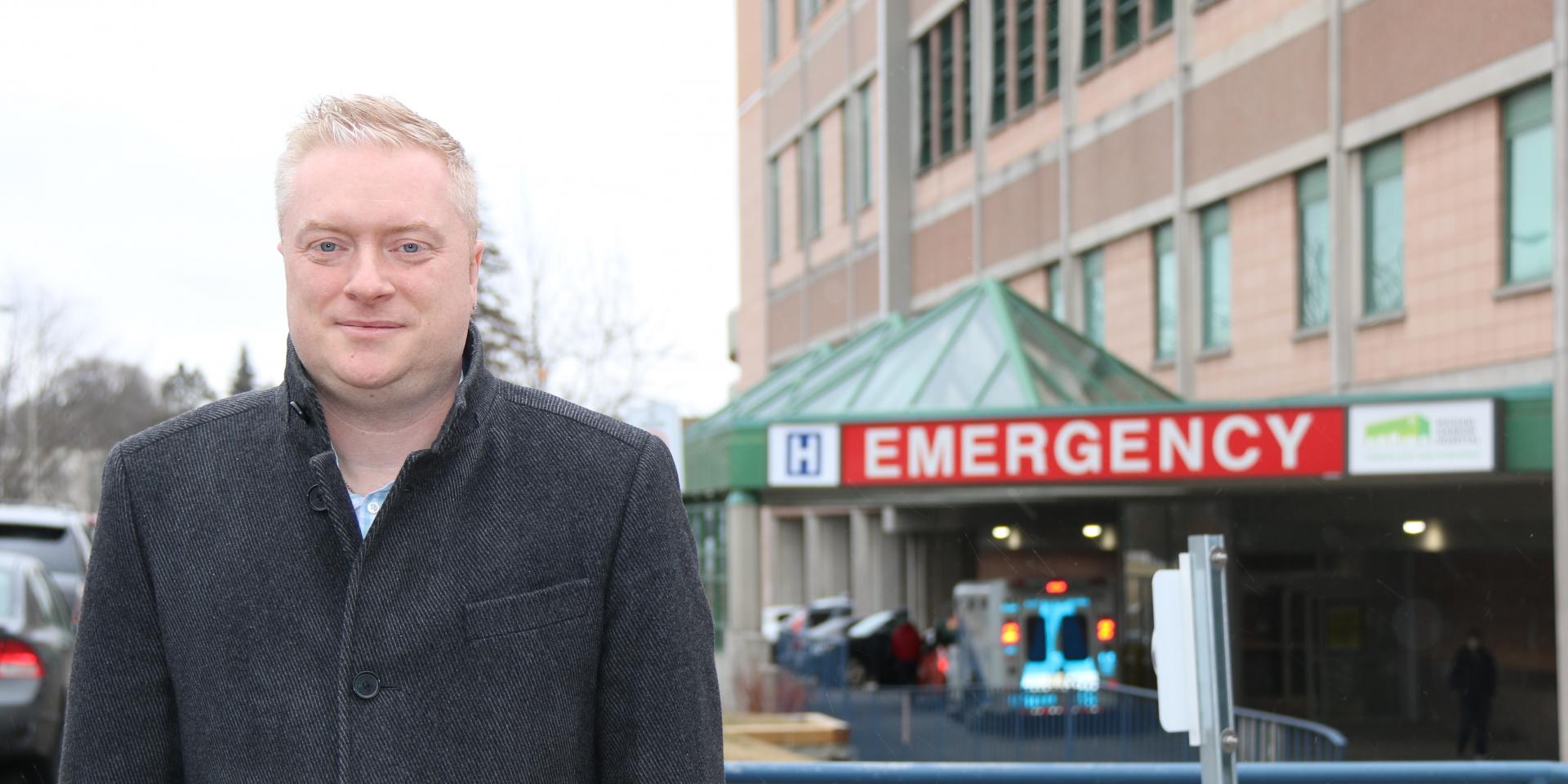 man standing outside in front of emergency department 