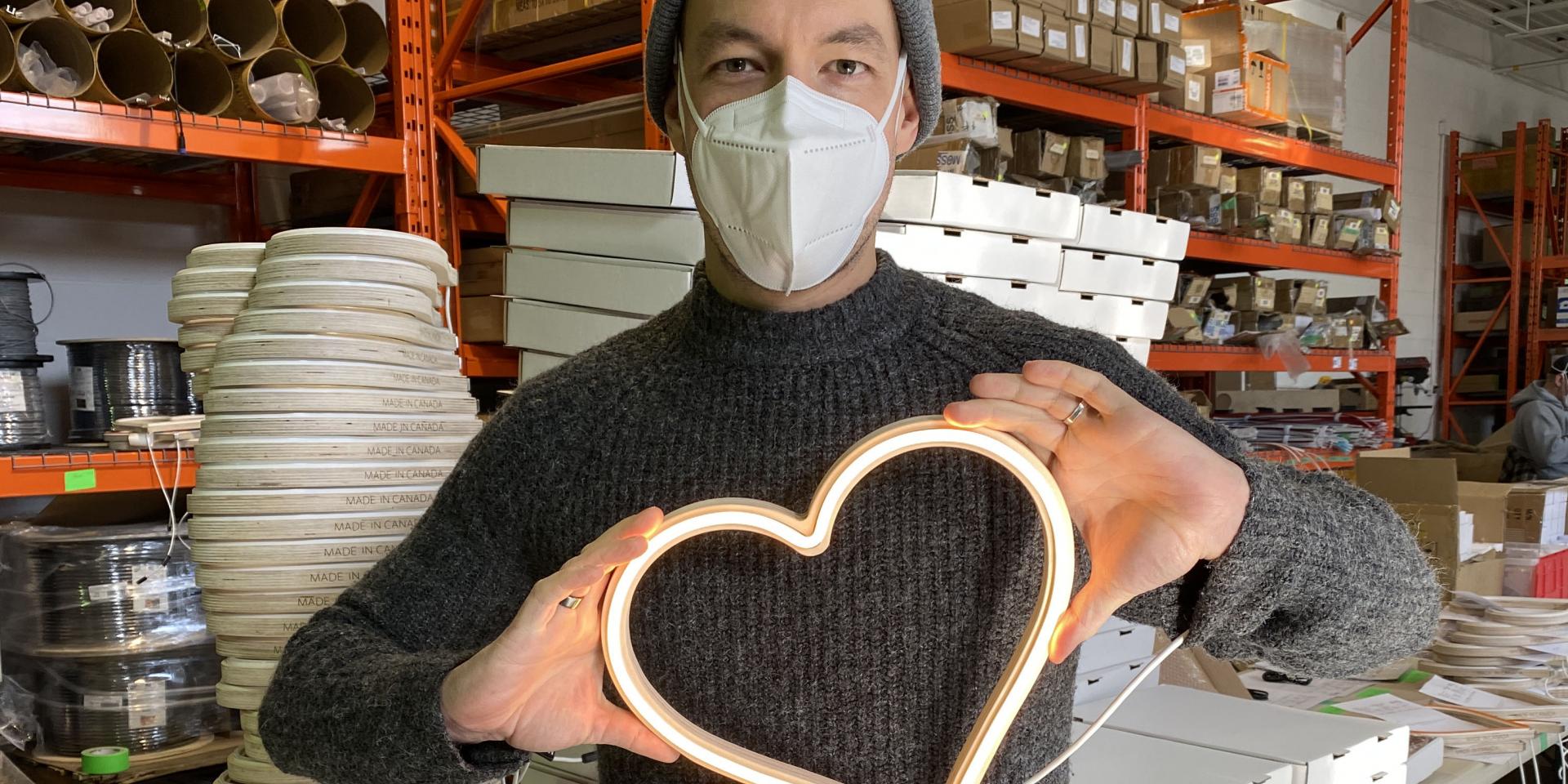 man holding LED heart