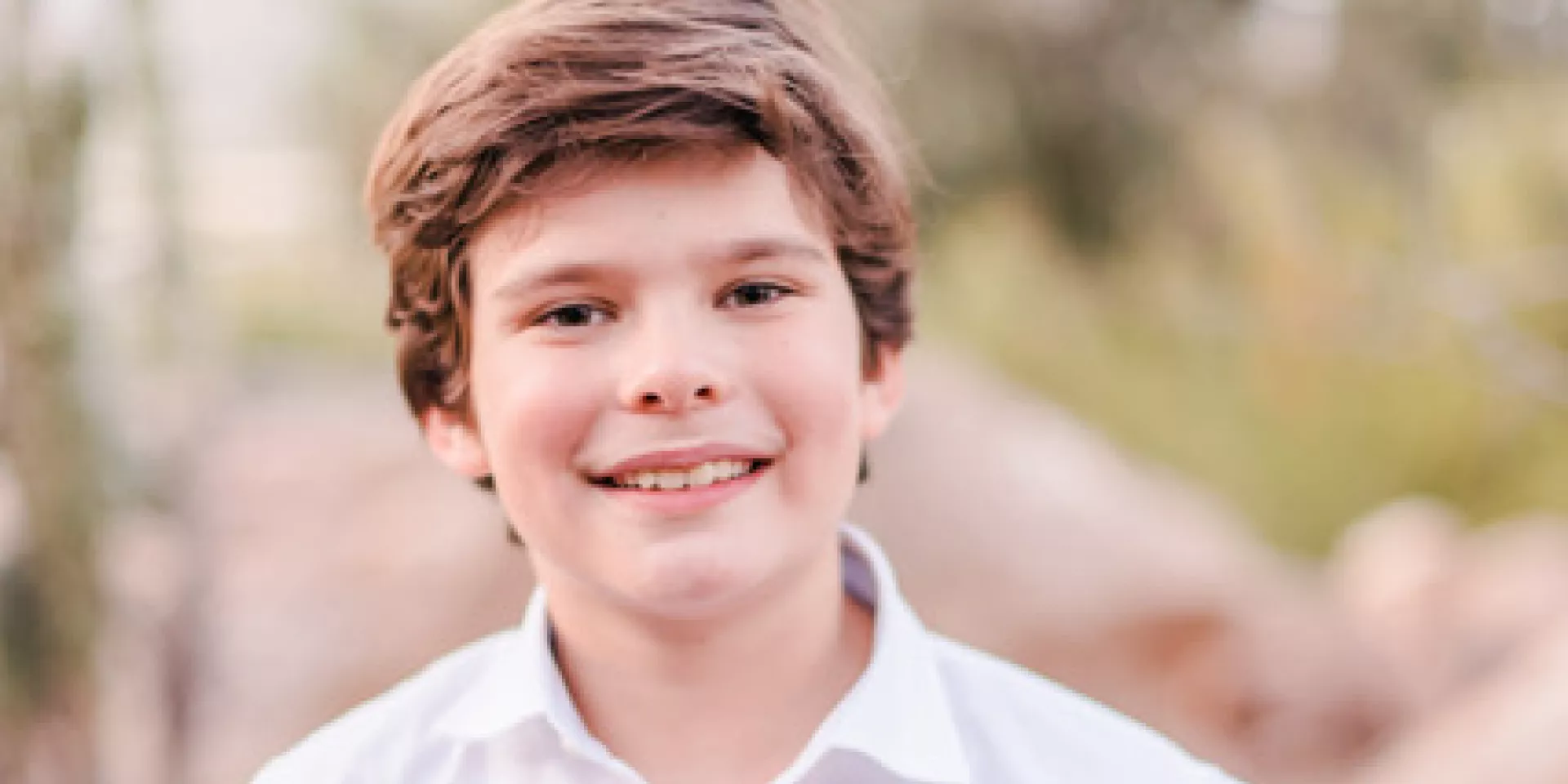 Karsten, a young boy wearing a white shirt, standing facing the camera 
