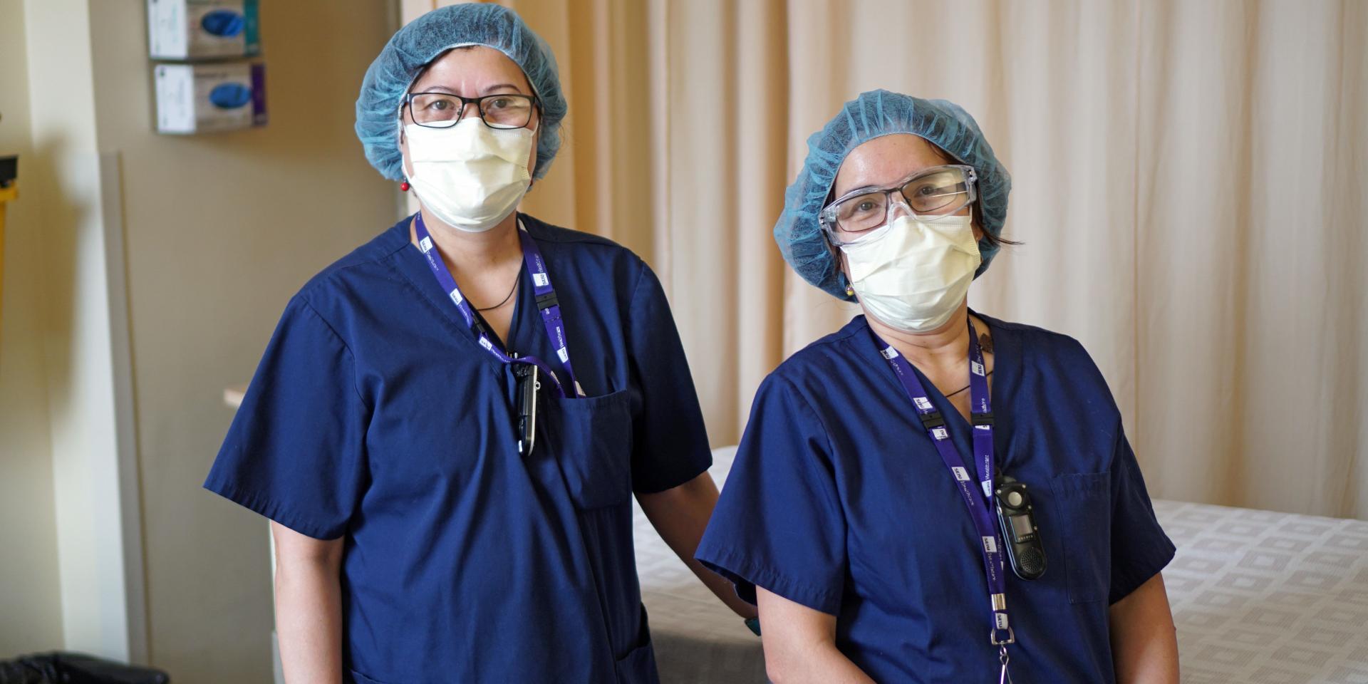 two masked healthcare workers facing the camera