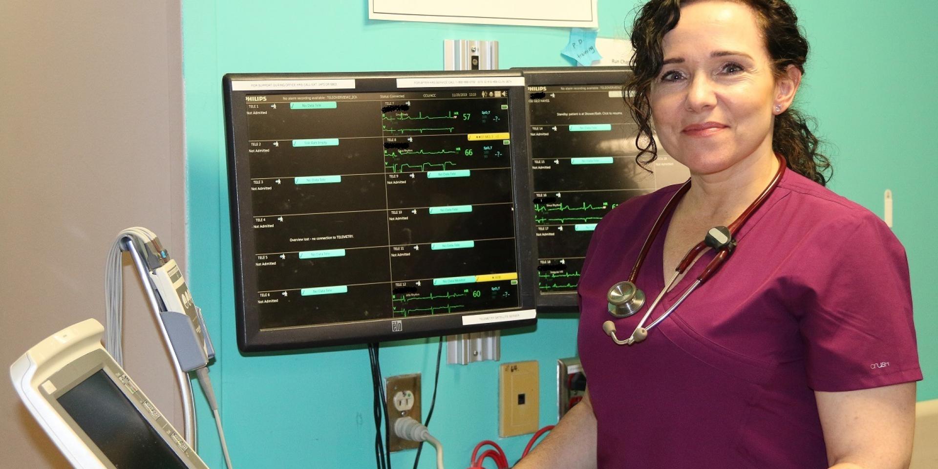 nurse standing in front of monitoring equipment 