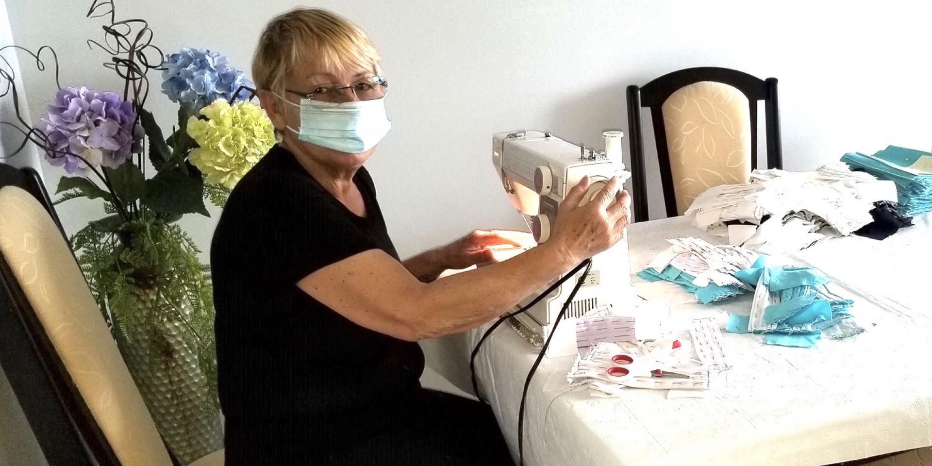 woman sitting at table behind sewing machine