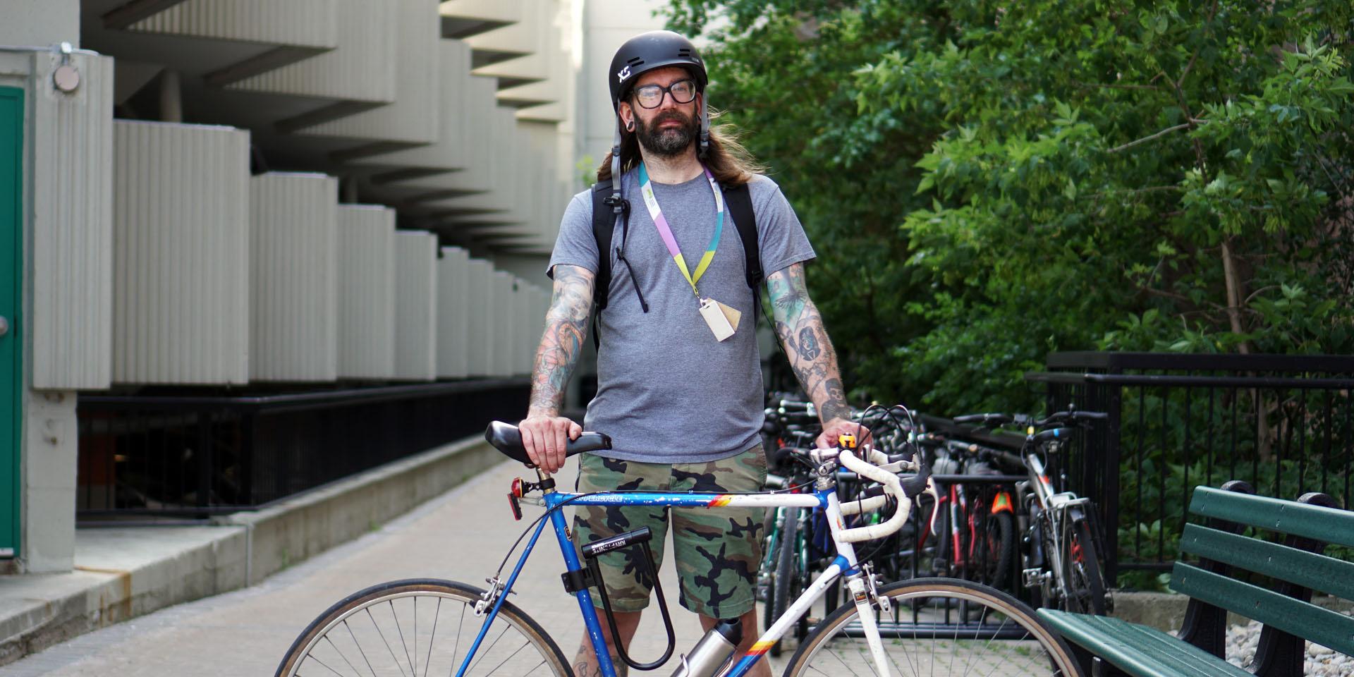 man standing holding bike 
