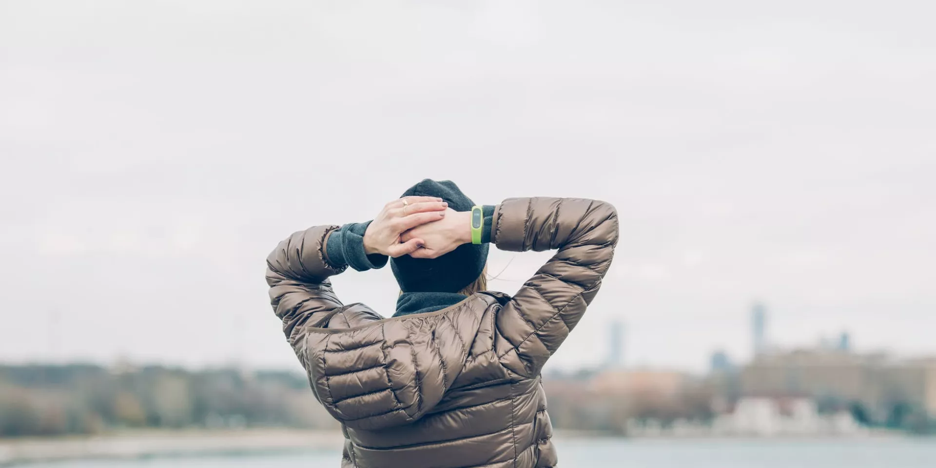 man holding behind head looking at water