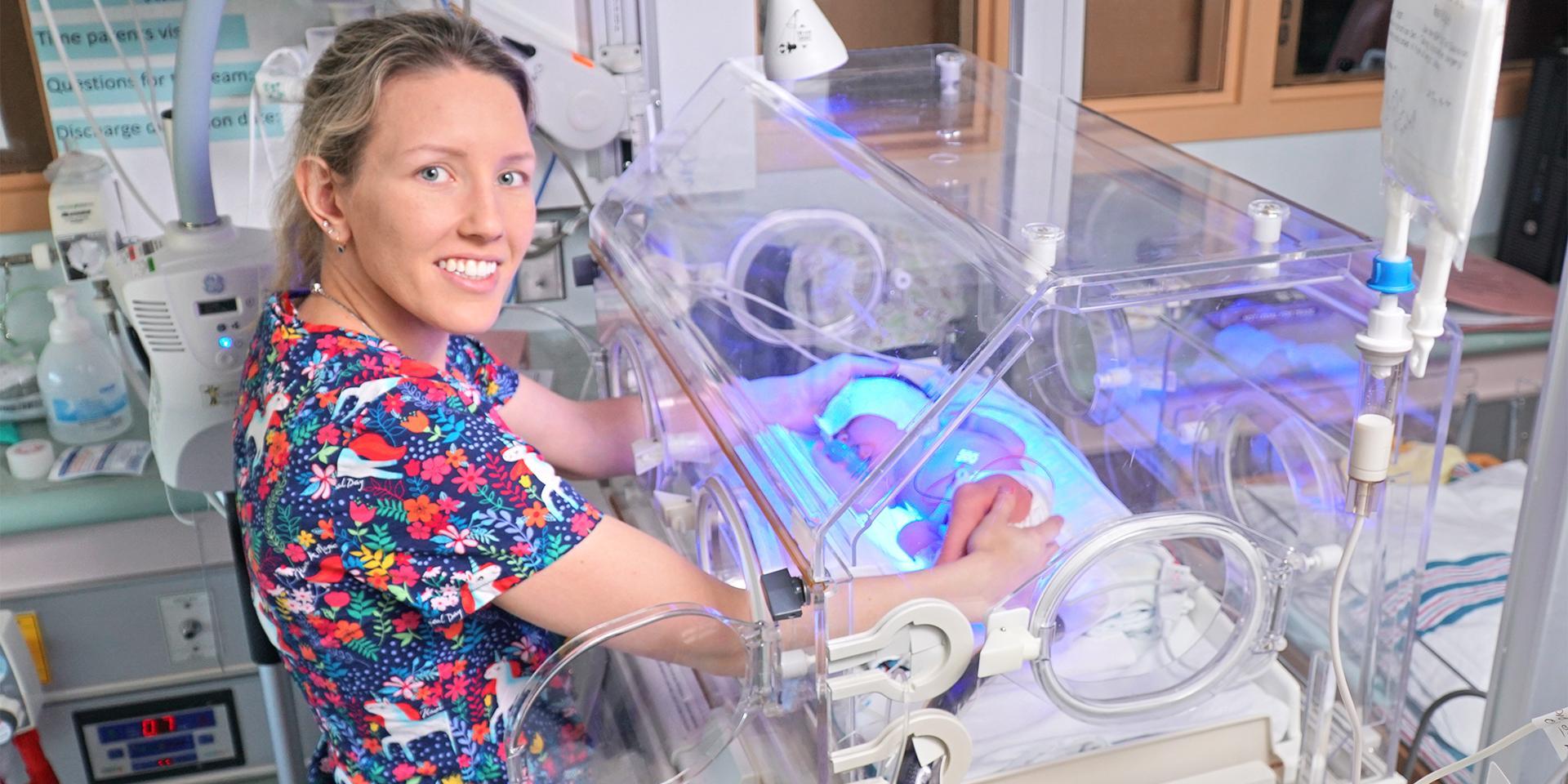 nurse standing next to incubator in special care nursery 
