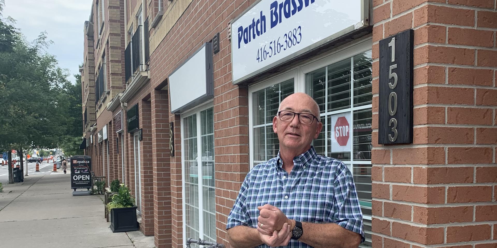 man standing on sidewalk in front of store