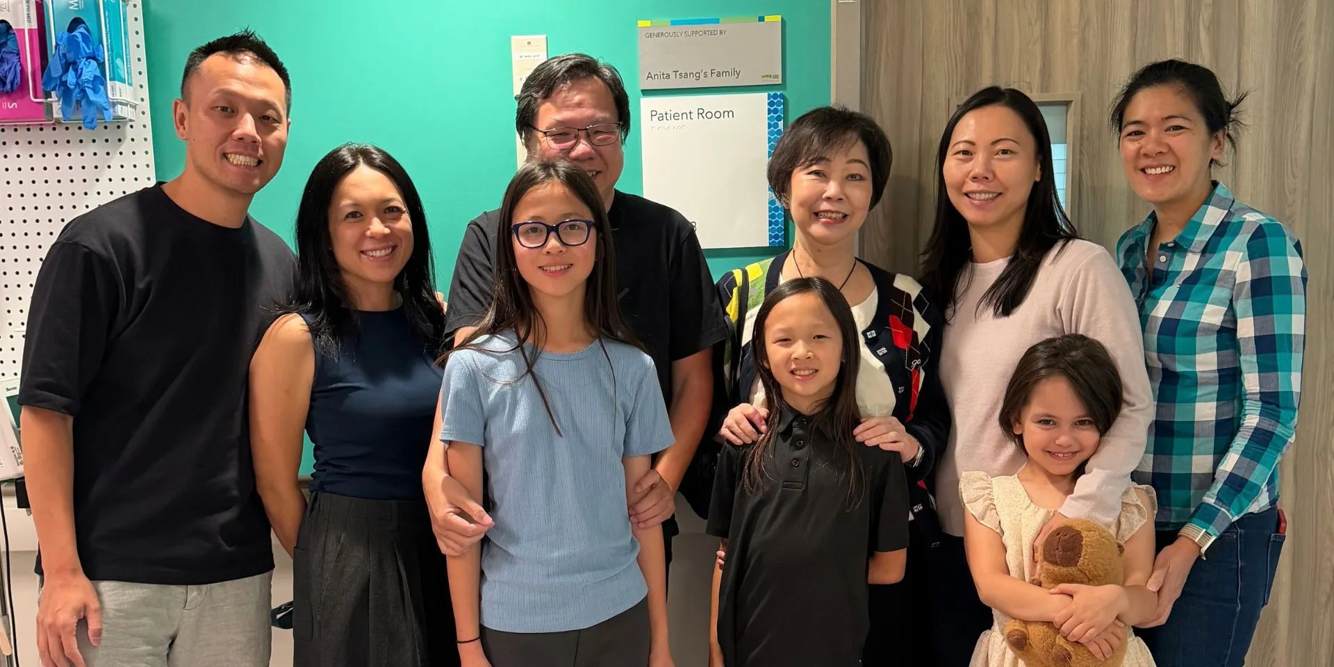 Members of the Tsang family stand alongside the plaque recognizing their support.
