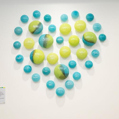 multiple glass orbs making the shape of a heart together on the wall.