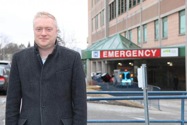 man standing outside in front of emergency department 