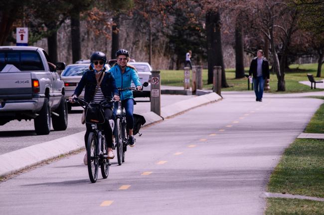 Two women riding bicycles on a bike path 