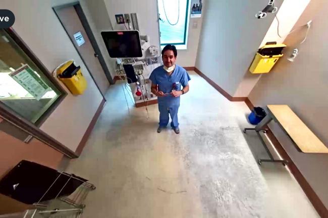 physician in room looking up at camera 