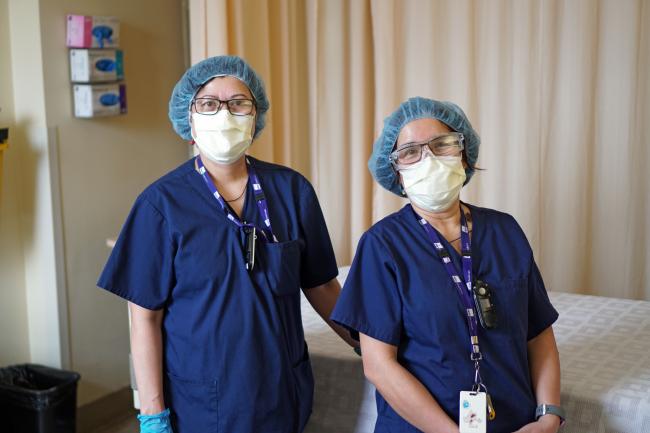 two masked healthcare workers facing the camera