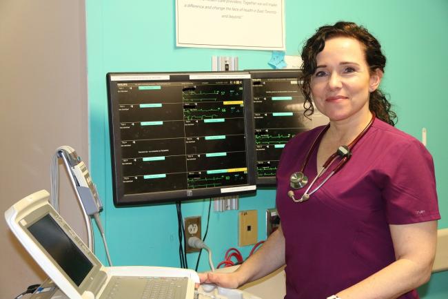 nurse standing in front of monitoring equipment 