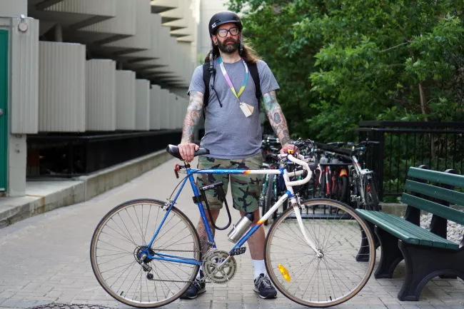 man standing holding bike 
