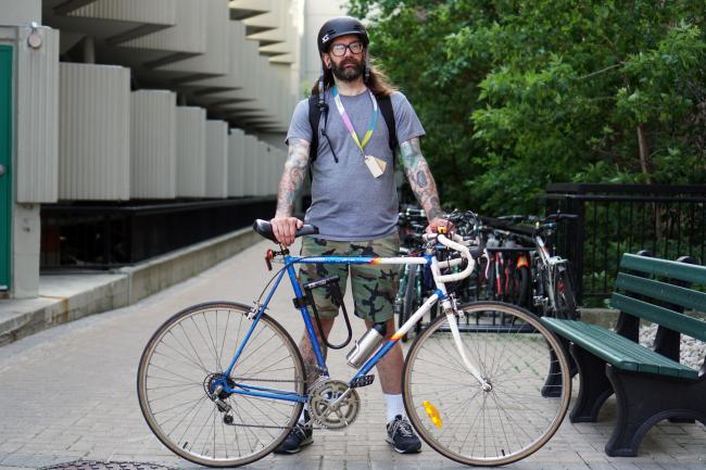 man standing holding bike 