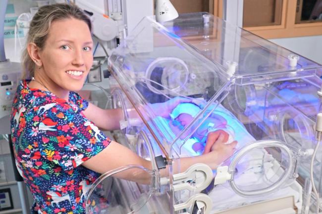 nurse standing next to incubator in special care nursery 