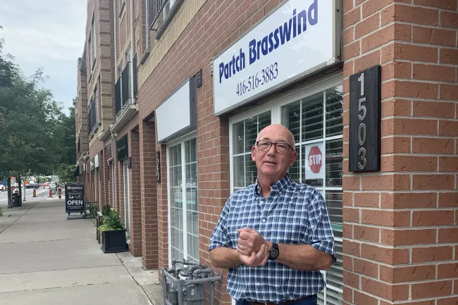man standing on sidewalk in front of store