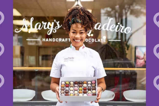 Mariane Oliveira from Mary's Brigadeiro Handcrafted Chocolates was one of the business owners who who held February fundraisers for Michael Garron Hospital. Mary Brigadeiro holding a box of chocolates in front of her chocolate store with a message saying "share the heart this valentine's day"