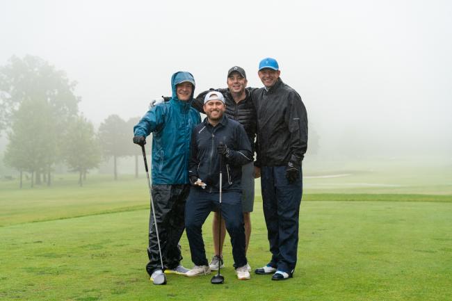 Golfers posing in the rain at the Golf Classic 2023