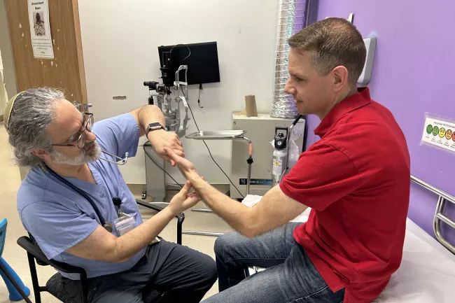 Dr. David Rosenstein, information technology lead for our Stavro Emergency Department, assesses a patient’s injured wrist.