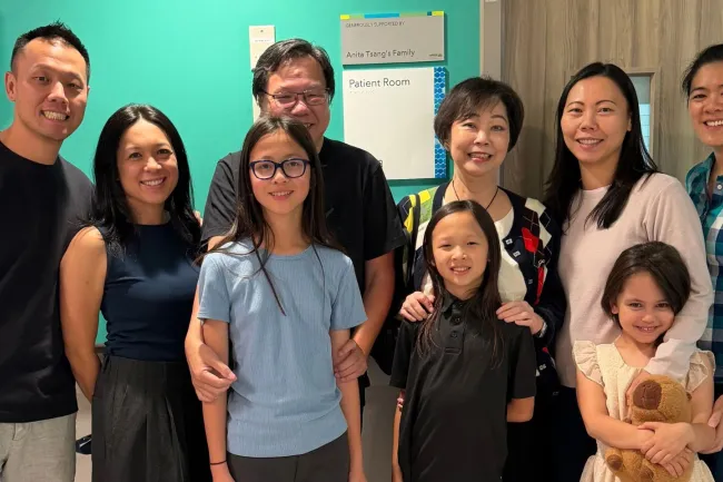 Members of the Tsang family stand alongside the plaque recognizing their support.