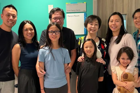 Members of the Tsang family stand alongside the plaque recognizing their support.