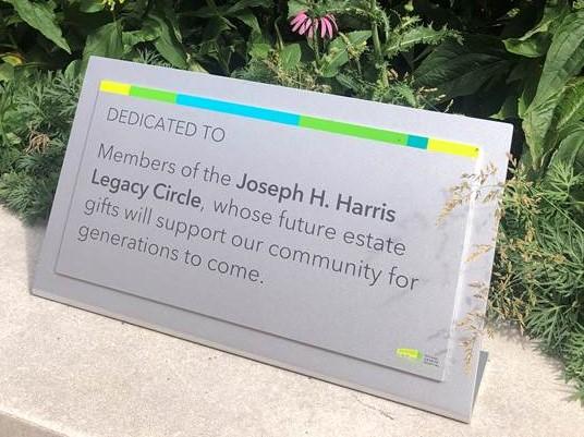 A plaque in a garden that shares information about the Legacy Circle